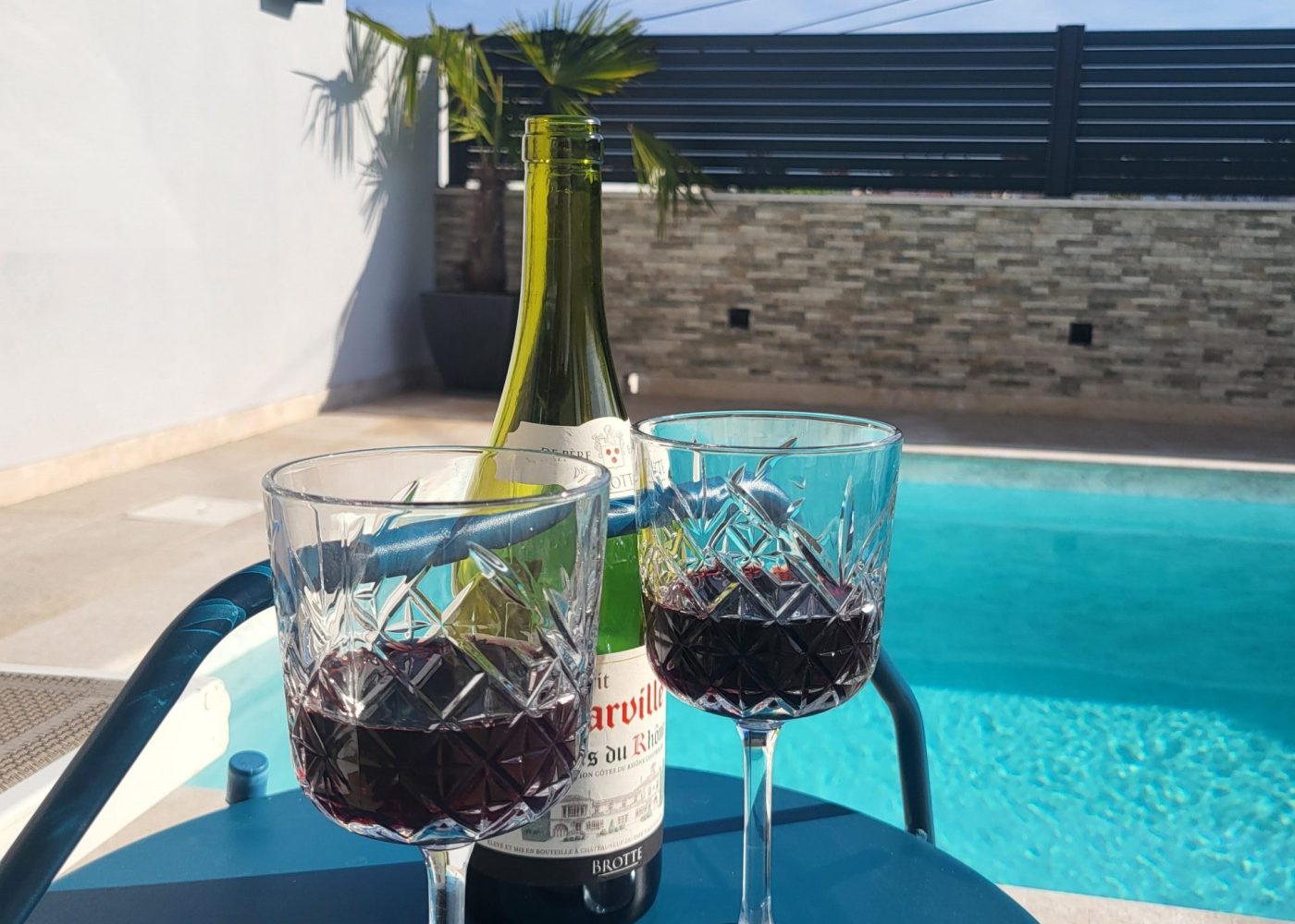 Mit einem Glas Wein im Pool abkühlen